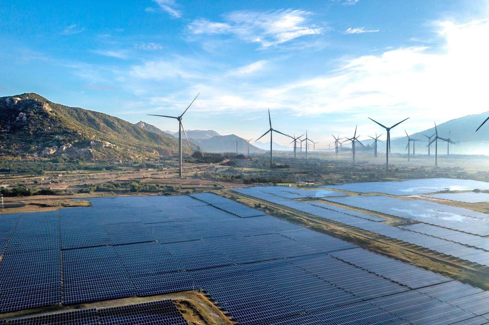 Solar farm and wind turbines across a valley