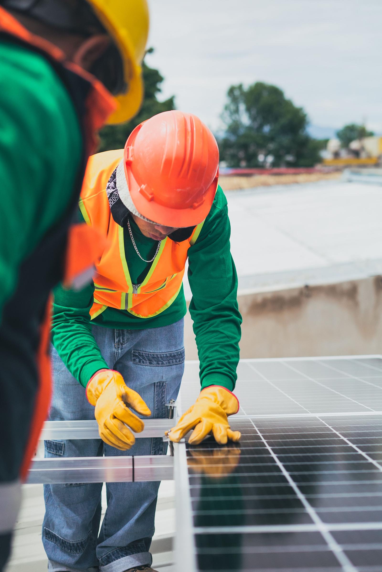 Technicians installing a solar panel array